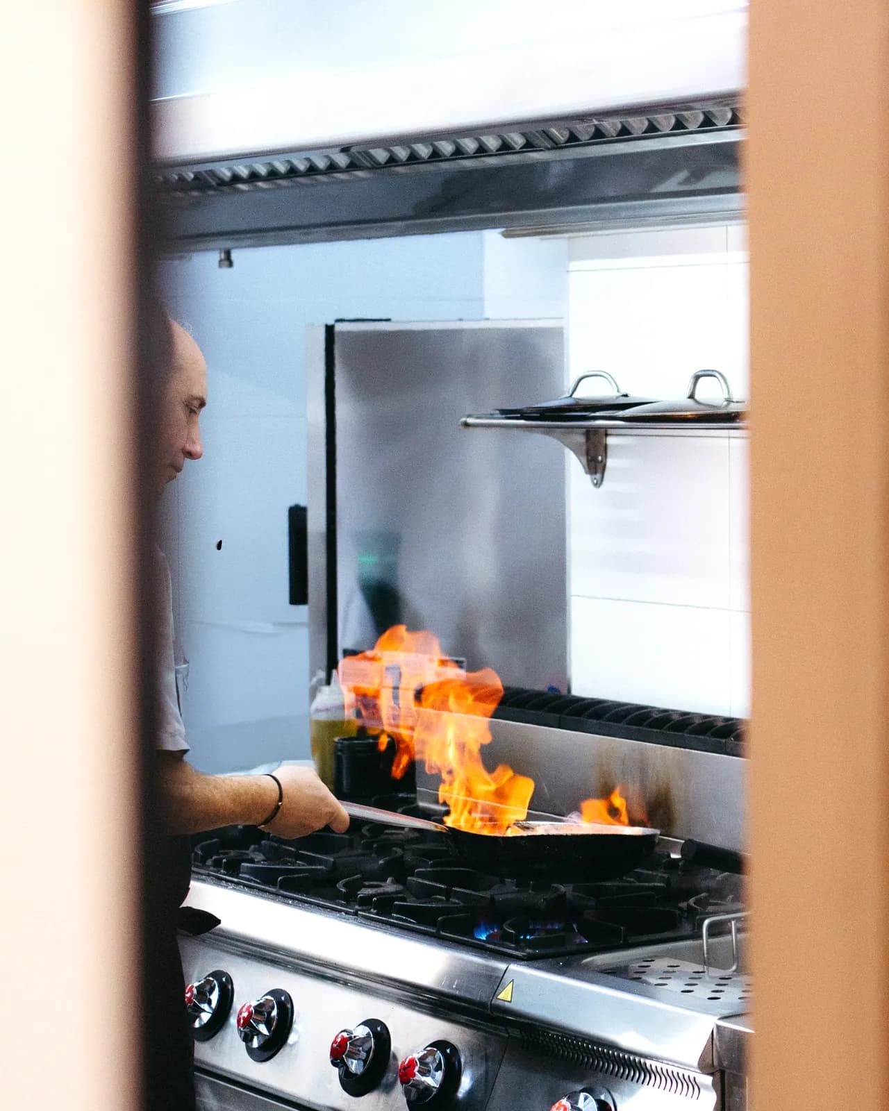 Chef Giancarlo Milano cocinando con flambé en la cocina del Restaurante Già